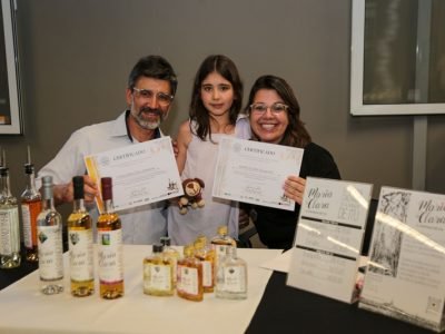 Eric Faustino e Cibele Silveira, produtores da Cachaça Maria Clara, de Itu, ao lado da filha Maria Clara, durante a premiação do II Concurso Estadual de Qualidade da Cachaça Paulista, em 2025. A Maria Clara Amburana conquistou Ouro, enquanto a Maria Clara Branquinha recebeu Prata.