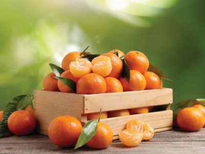 Fresh,Juicy,Tangerines,In,Crate,On,Wooden,Table,Against,Blurred
