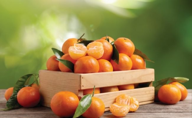 Fresh,Juicy,Tangerines,In,Crate,On,Wooden,Table,Against,Blurred