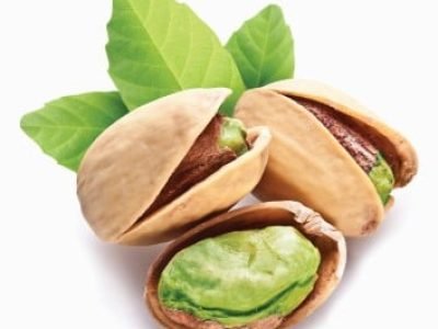 Pistachio nuts with leaves isolated on a white background.