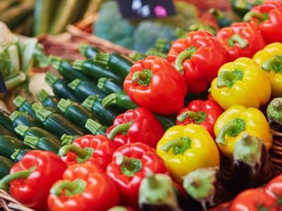 Pimentões coloridos frescos ao lado de colher com páprica