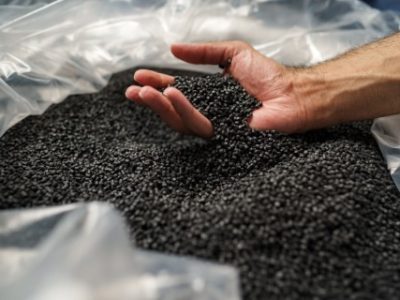 Close up photo of male hand holding plastic polymer granules