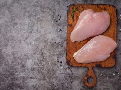Raw chicken breast on the dark background.