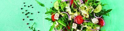 Salad of fresh vegetables - tomato, cucumber and feta cheese in Greek style. Flat lay. Top view