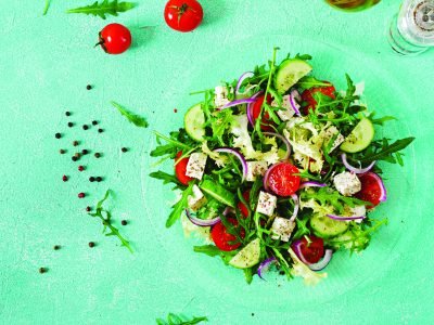 Salad of fresh vegetables - tomato, cucumber and feta cheese in Greek style. Flat lay. Top view
